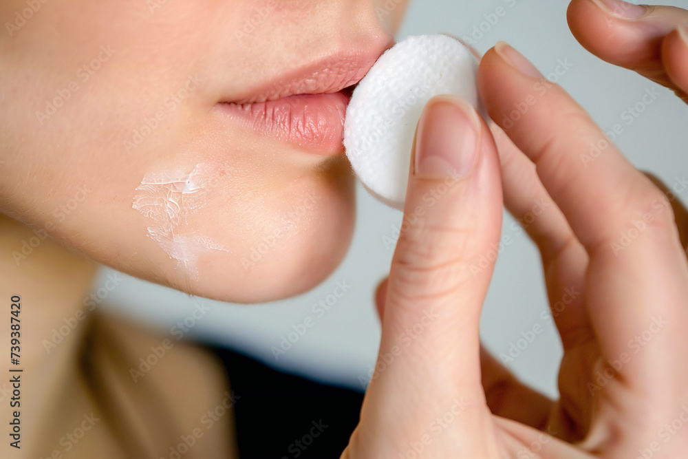 Woman removing makeup with a cotton pad Woman removing makeup with a cotton pad