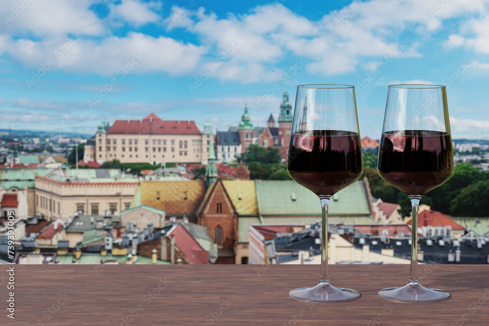 Φωτογραφία Two glasses of red wine on view of Krakow city center with Wawel castle from abo