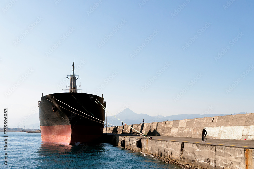 Ship at Heraklion Port with cyclist on the right and the mountains in the background