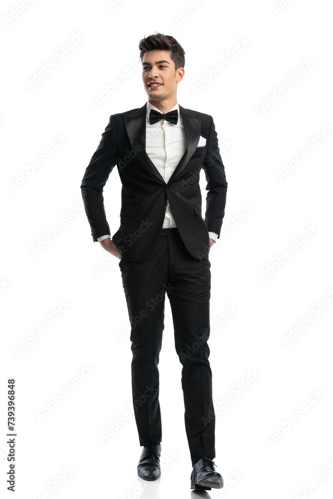 happy elegant groom in black tuxedo looking to side and smiling happy elegant groom in black tuxedo looking to side and smiling