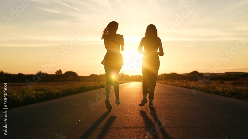 two friends running sunset, team group girls running sunset, silhouette athletic girls, teamwork athletic woman running on trail at sunset, running man, jogging, athlete legs rest, triathlete photo