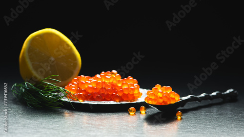Caviar. Trout Eggs in spoon on black background.