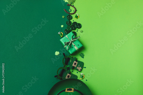 Patrick Day festive green background decorated with shamrocks, leprechaun hat, coins, eyeglasses, horseshoe and gifts top view.