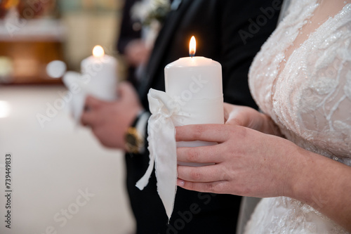the bride and groom hold wedding candles