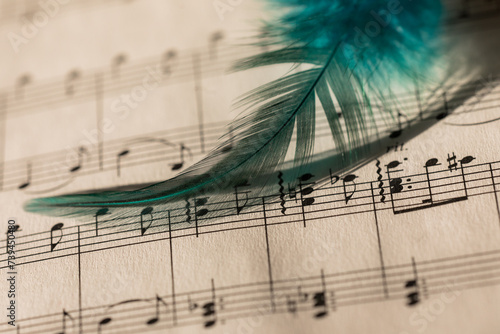 piano sheet on paper with a turquoise feather, vintage style
