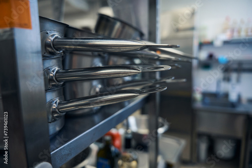 Shiny, polished frying pans on kitchen racks