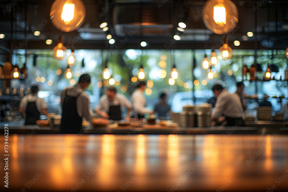 Blurry view of a busy restaurant interior with hanging lights and staff working Blurry view of a busy restaurant interior with hanging lights and staff working