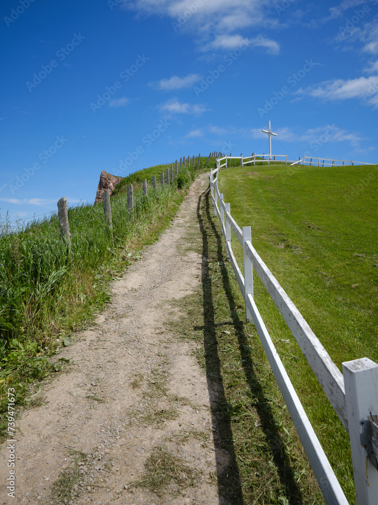 White Cross on the Hilltop at the Mont Joli Lookout in Perce on the Gaspe Peninsula on the Gulf of St. Lawrence in Quebec Canada White Cross on the Hilltop at the Mont Joli Lookout in Perce on the Gaspe Peninsula on the Gulf of St. Lawrence in Quebec Canada