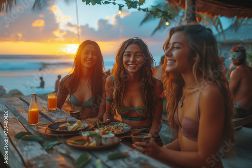Sunset vibes at a beachfront gathering, where a group of friends with radiant smiles share a meal and drinks, basking in the golden glow photo