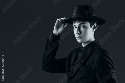 portrait of a young man in a suit with a hat, shot in the studio in black and white