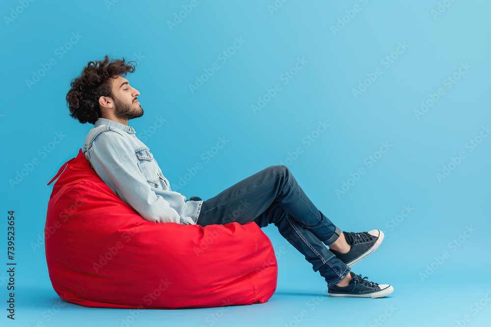 Happy smiling man sitting on comfortable beanbag chair Happy smiling man sitting on comfortable beanbag chair