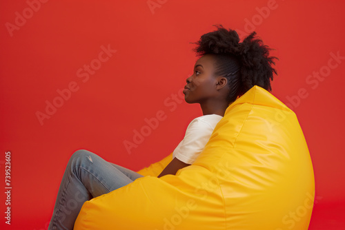 Handsome african american woman sitting on comfortable beanbag chair © Alina