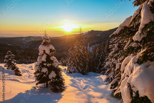 Sunrise over snowy mountain landscape of Kor Alps, Carinthia Styria, Austria. Snow covered alpine pine trees in soft red orange light. Tranquil serene atmosphere in winter wonderland, Austrian Alps photo
