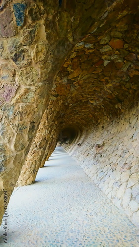Barcelona, Spain - 05.30.2018: An empty passage in Parc-Guell with curved ceiling and tilted pillars photo
