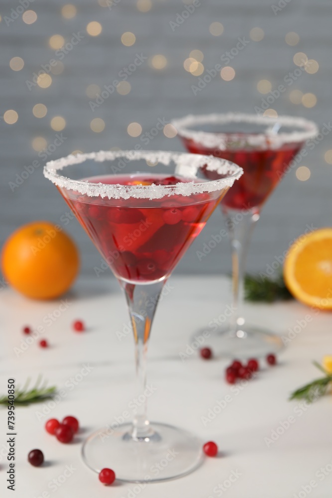 Tasty cranberry cocktail in glasses on white table Tasty cranberry cocktail in glasses on white table