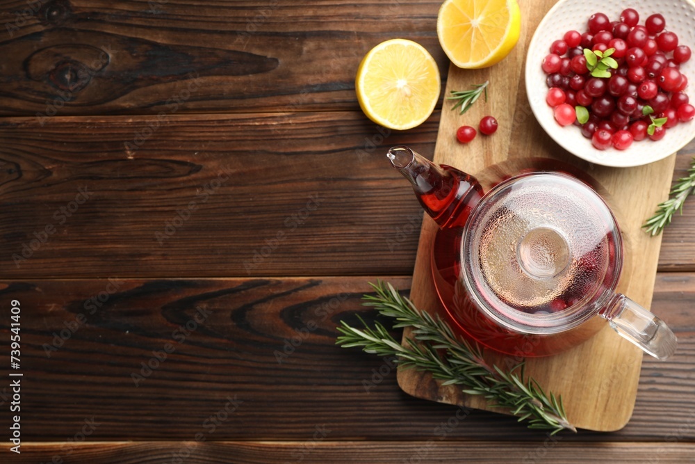 Tasty hot cranberry tea, lemon, rosemary and fresh berries on wooden table Tasty hot cranberry tea, lemon, rosemary and fresh berries on wooden table