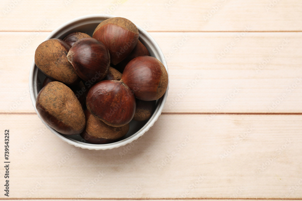 Sweet fresh edible chestnuts on light wooden table, top view. Space for text Sweet fresh edible chestnuts on light wooden table, top view. Space for text