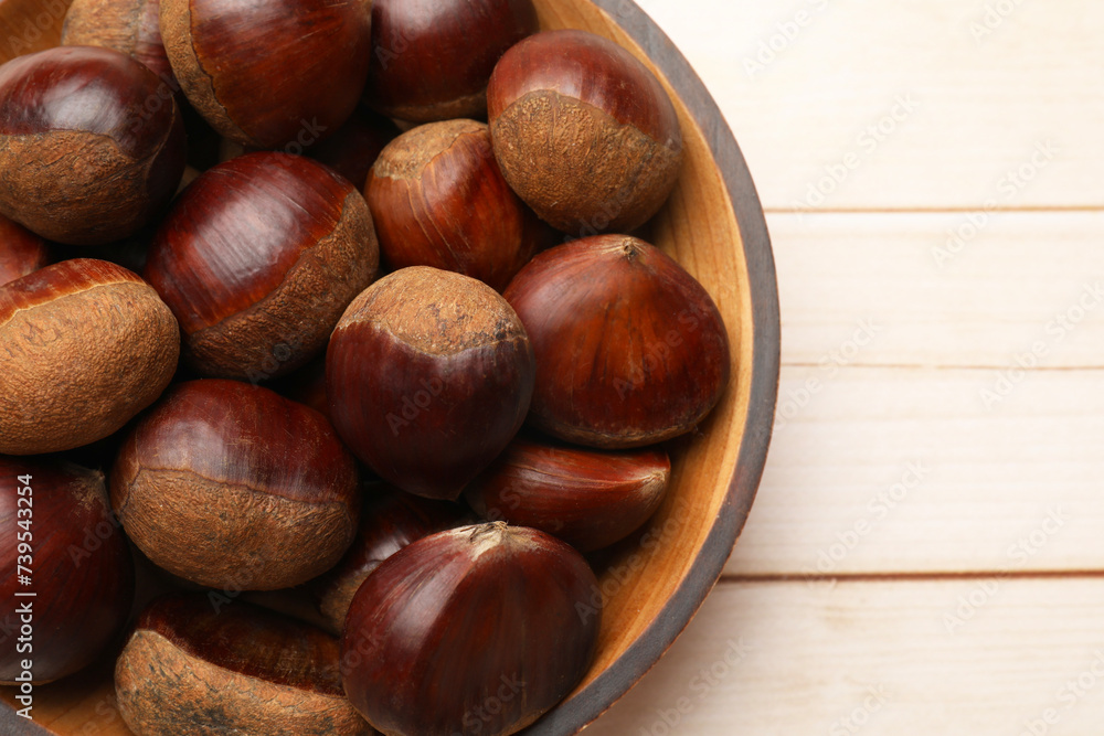 Sweet fresh edible chestnuts on light wooden table, top view. Space for text Sweet fresh edible chestnuts on light wooden table, top view. Space for text