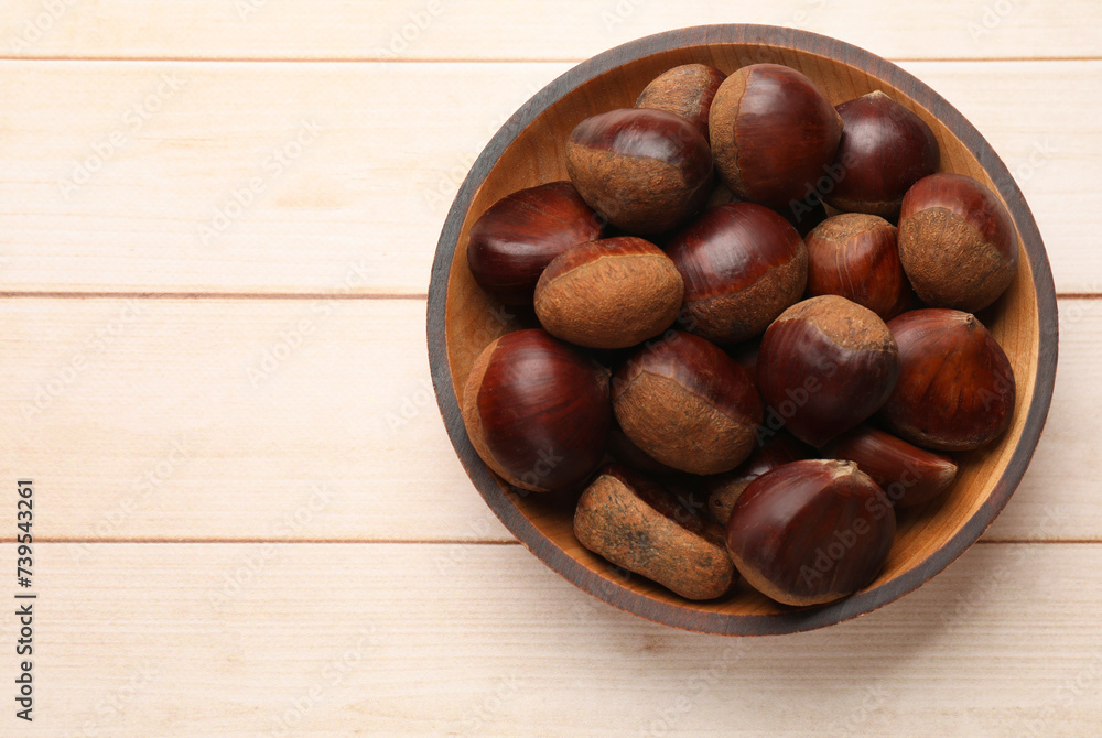 Sweet fresh edible chestnuts on light wooden table, top view. Space for text Sweet fresh edible chestnuts on light wooden table, top view. Space for text