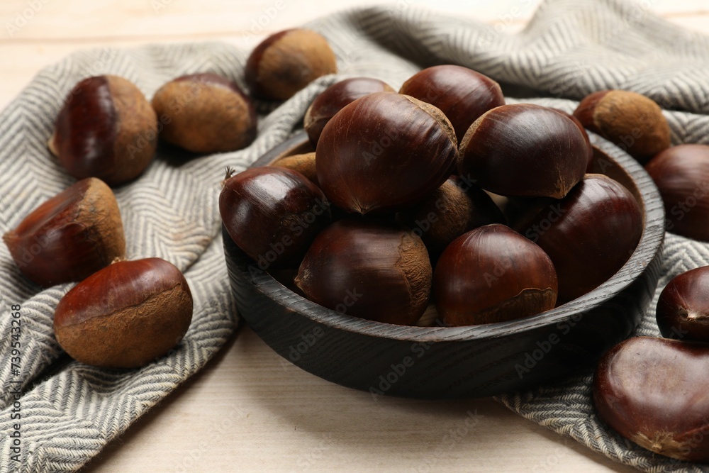 Sweet fresh edible chestnuts on light wooden table, closeup Sweet fresh edible chestnuts on light wooden table, closeup