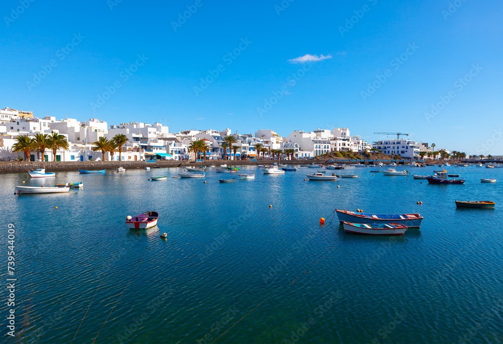 Awesome blue lagoon in Arrecife Lanzarote, Canary Islands Spain. Moored fishing boats on Atlantic bay