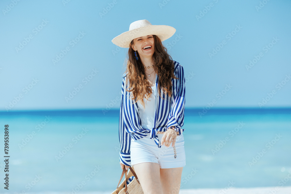 smiling stylish female on beach with straw hat smiling stylish female on beach with straw hat