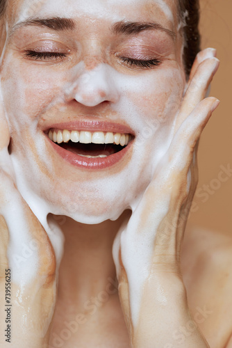Quadro su tela smiling young female with foaming face wash washing face