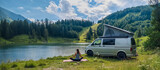un van de camping garé à côté d'un lac, et une femme qui fait du yoga à côté