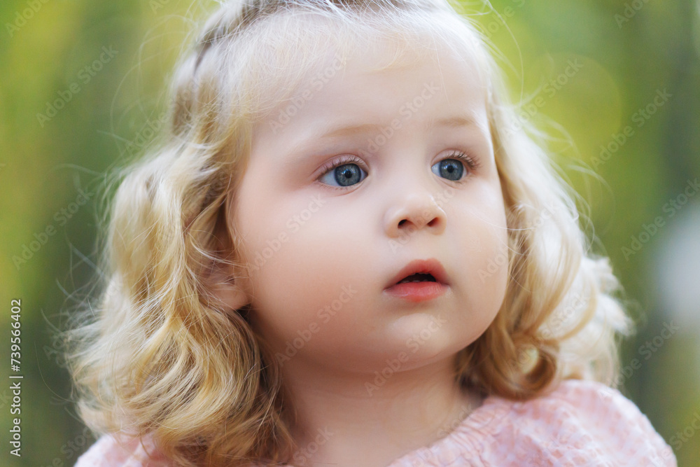 Beautiful child in spring park. Happy kid having fun outdoors. Closeup of pretty cute little girl with long hair Beautiful child in spring park. Happy kid having fun outdoors. Closeup of pretty cute little girl with long hair