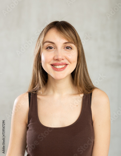 Portrait of smiling young woman in casual clothes in studio