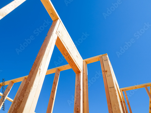 Framing of exterior, interior walls on traditional timber house new build construction, joints, post, beam connection of medium size single family residential home, Dallas, Texas, clear blue sky