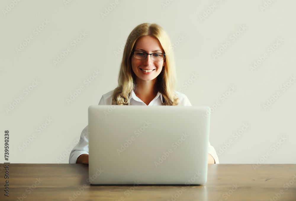 Naklejka premium Happy woman working with laptop sitting at desk in office or home