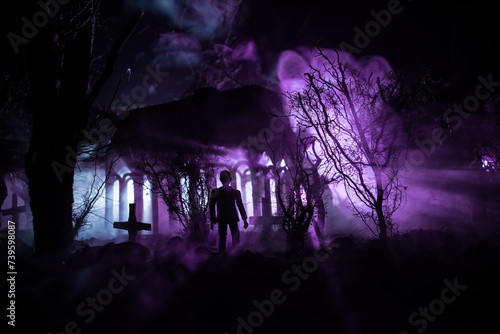 Silhouette of person standing in the dark forest with light. Horror halloween concept.