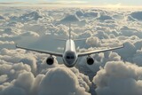 A modern passenger airplane is seen flying high above the clouds in the sky.