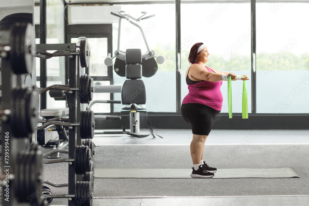 Fototapeta premium Woman at a gym exercising with a resistance band