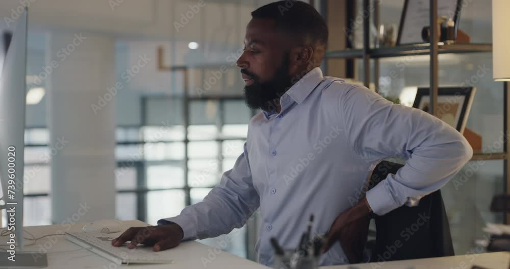 Back pain, computer and businessman for working in office, spine problem and stretching by desk. African accountant, desktop and typing in chair, muscle strain and inflammation and night at company Back pain, computer and businessman for working in office, spine problem and stretching by desk. African accountant, desktop and typing in chair, muscle strain and inflammation and night at company