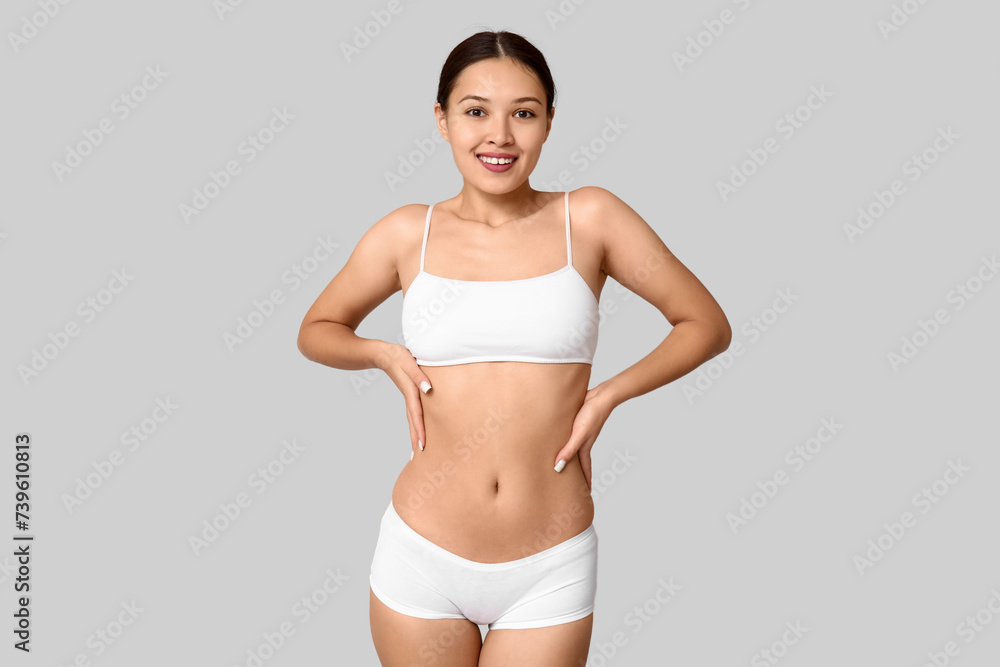 Fototapeta premium Slim young woman in underwear on light background. Weight loss concept