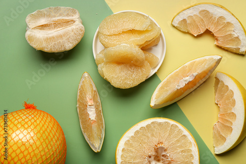 Sweet pomelo with slices on colorful background