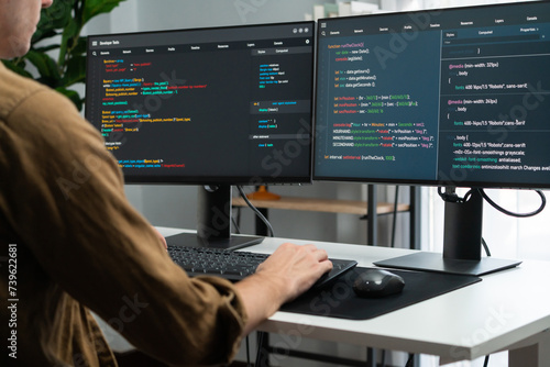 Obraz w ramie IT developer working online software development on pc monitors at modern home office on coding application screens, creating updated latest program firmware information version concept. Gusher.