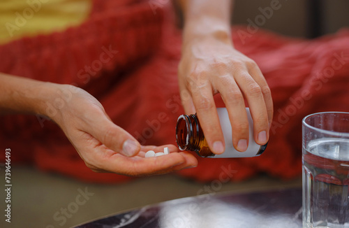 adult sick ill man hold pills on hand pouring capsules from medication bottle, take painkiller supplement medicine, people pharmaceutical healthcare treatment concept, close up view at home
