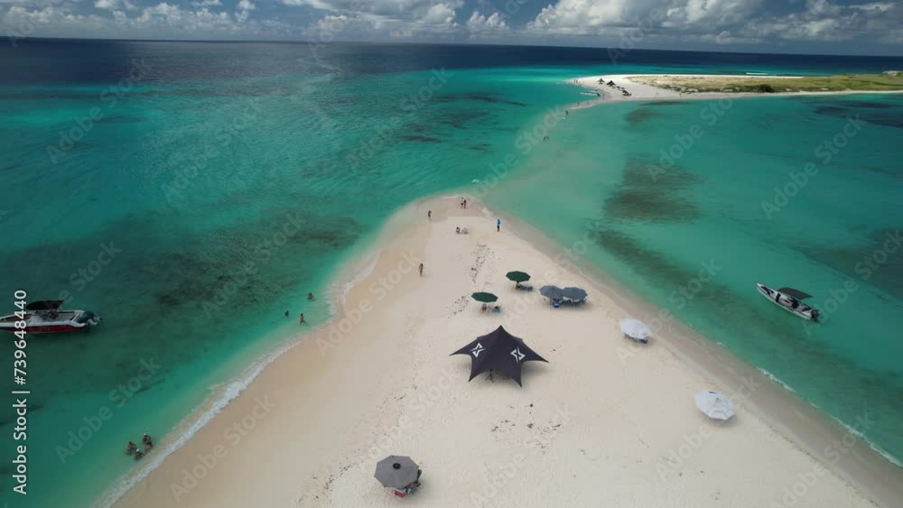Aerial zoom in cayo de agua island, people enjoy day beach, white sand, boats and beach umbrellas Aerial zoom in cayo de agua island, people enjoy day beach, white sand, boats and beach umbrellas