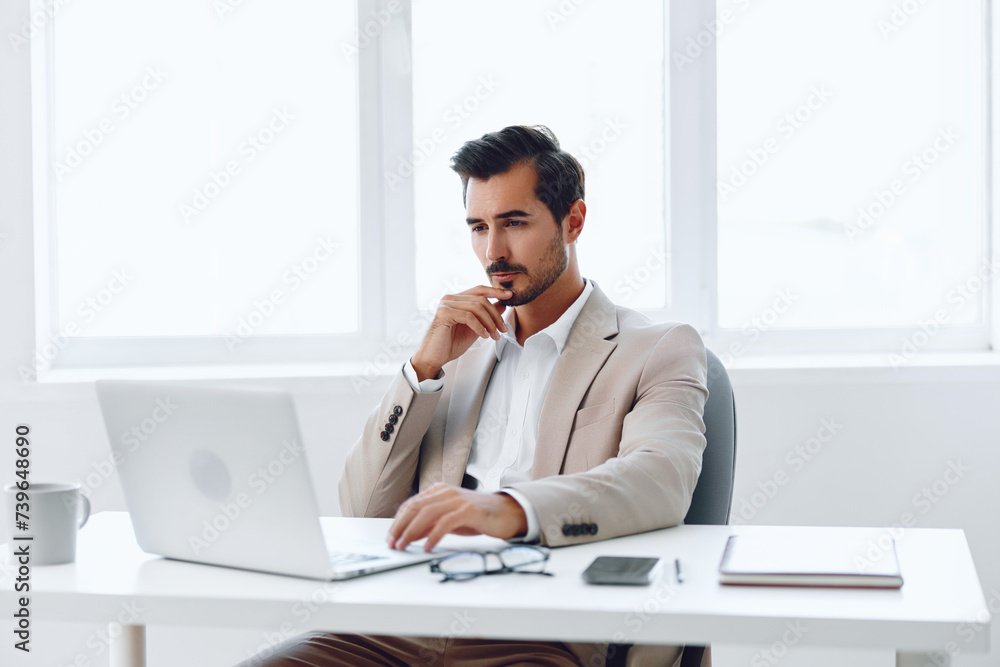 Man in office businessman sitting at desk and working in laptop and talking on phone, modern suit, finance and startup concept and data analysis, working lifestyle in bright office. Man in office businessman sitting at desk and working in laptop and talking on phone, modern suit, finance and startup concept and data analysis, working lifestyle in bright office.