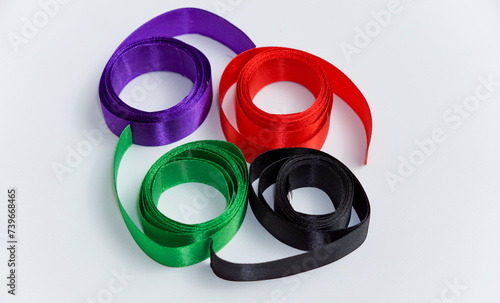 an unrolled roll of red, green, black, and purple ribbon isolated on a white background