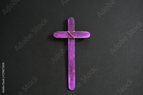 Obraz na płótnie A purple wooden cross in black background. Christian faith, holy week or lent season celebration concept. w salonie