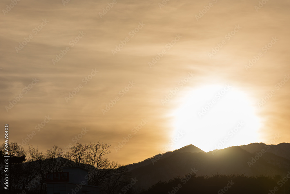 Orange sunset scenery - the sun setting over the mountains Orange sunset scenery - the sun setting over the mountains