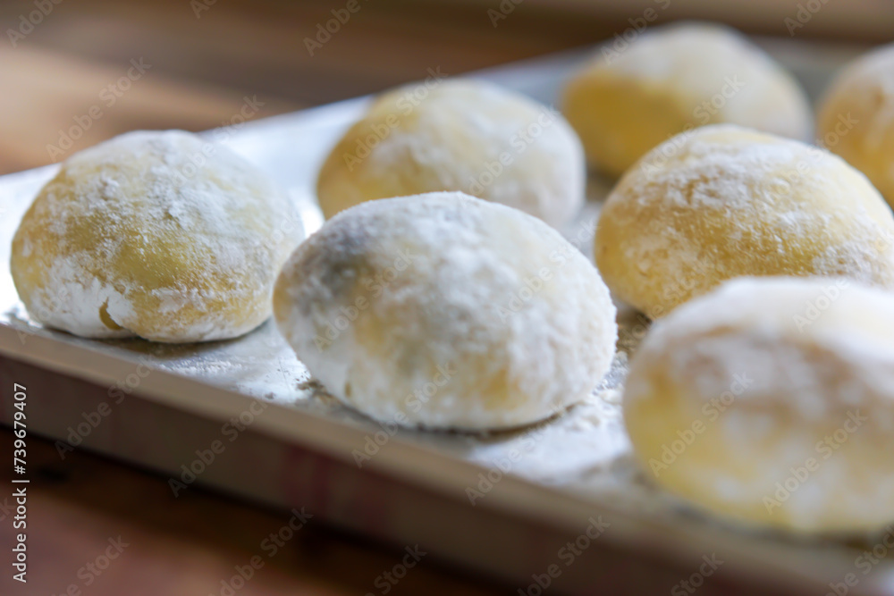 Small balls of fresh uncooked homemade donuts on a wooden table