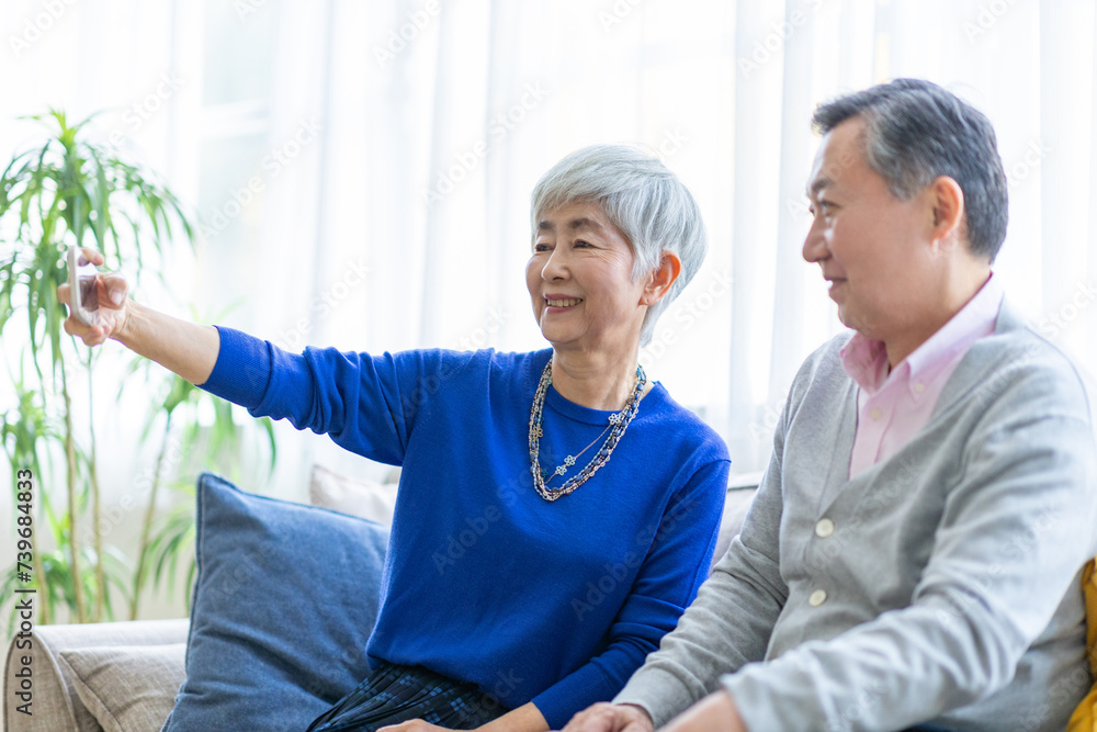 Obraz premium スマホで写真を撮るシニア男女