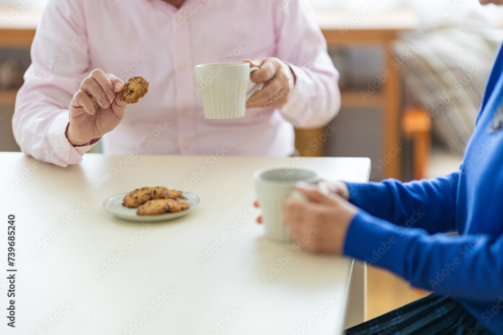 お茶の時間を楽しむシニア男女の手元 お茶の時間を楽しむシニア男女の手元