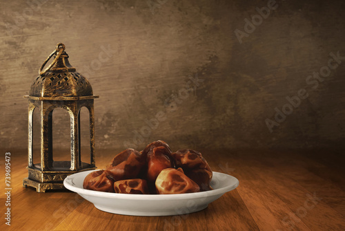 Arabic lantern and bowl of fresh dried dates on wooden floor, Ramadan kareem background
