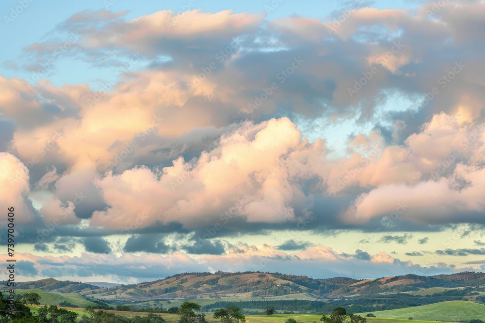 Billowing clouds drifting lazily across a pastel sky, casting soothing shadows over rolling hills